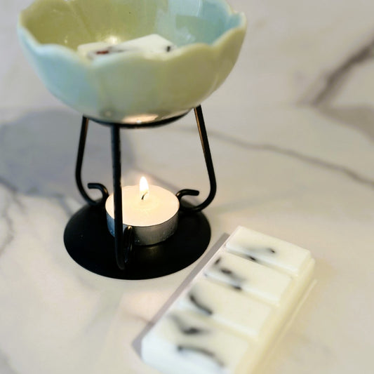 Spring Bluebell wax melt melting in a ceramic burner with soft flame and natural light.