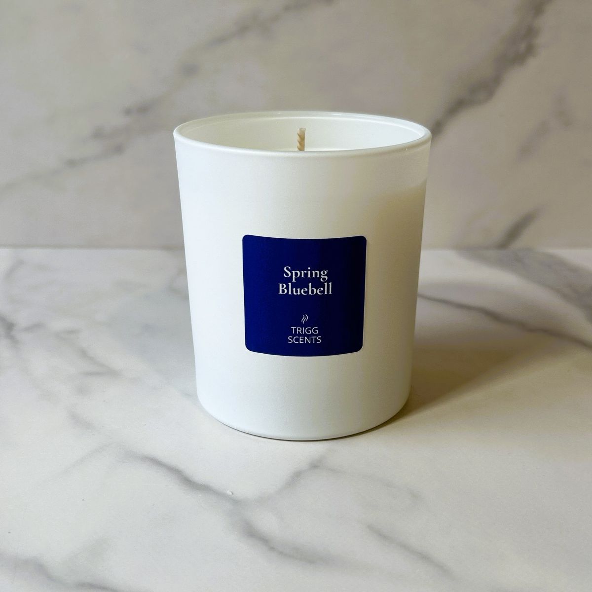 Spring Bluebell scented soy candle by TRIGG SCENTS with bluebell and hyacinth fragrance on marble background.