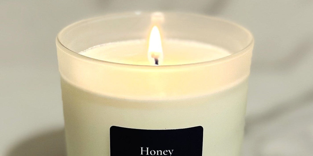 Lit scented candle with warm flame and soft wax surface