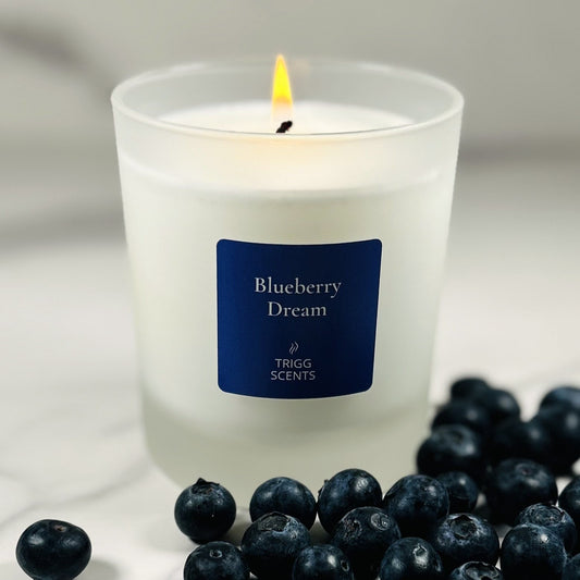 Blueberry Dream scented candle in a frosted glass jar with fresh blueberries, highlighting the blueberry fragrance