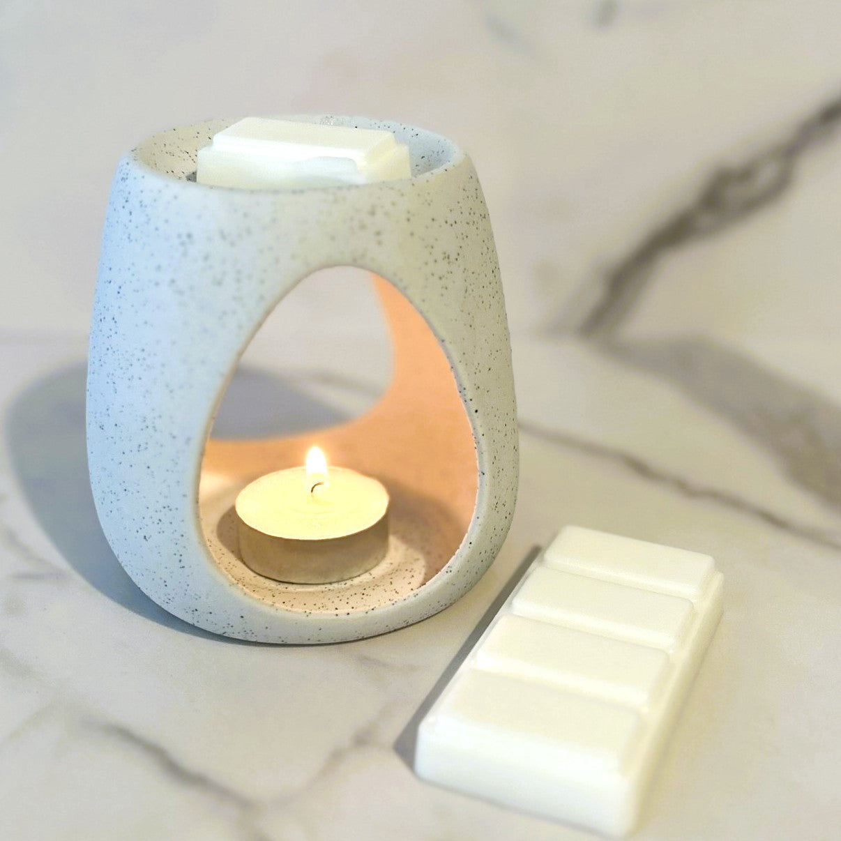 Petal Peach wax melt melting in a ceramic burner, creating a soft and uplifting home fragrance
