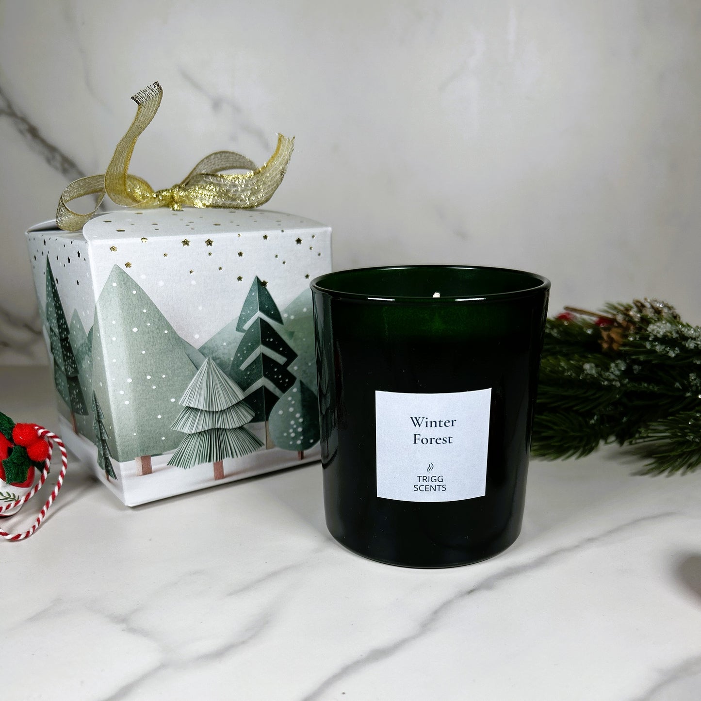 Winter Forest luxury candle by TRIGG SCENTS in green glass jar with festive Christmas gift box and pine decoration