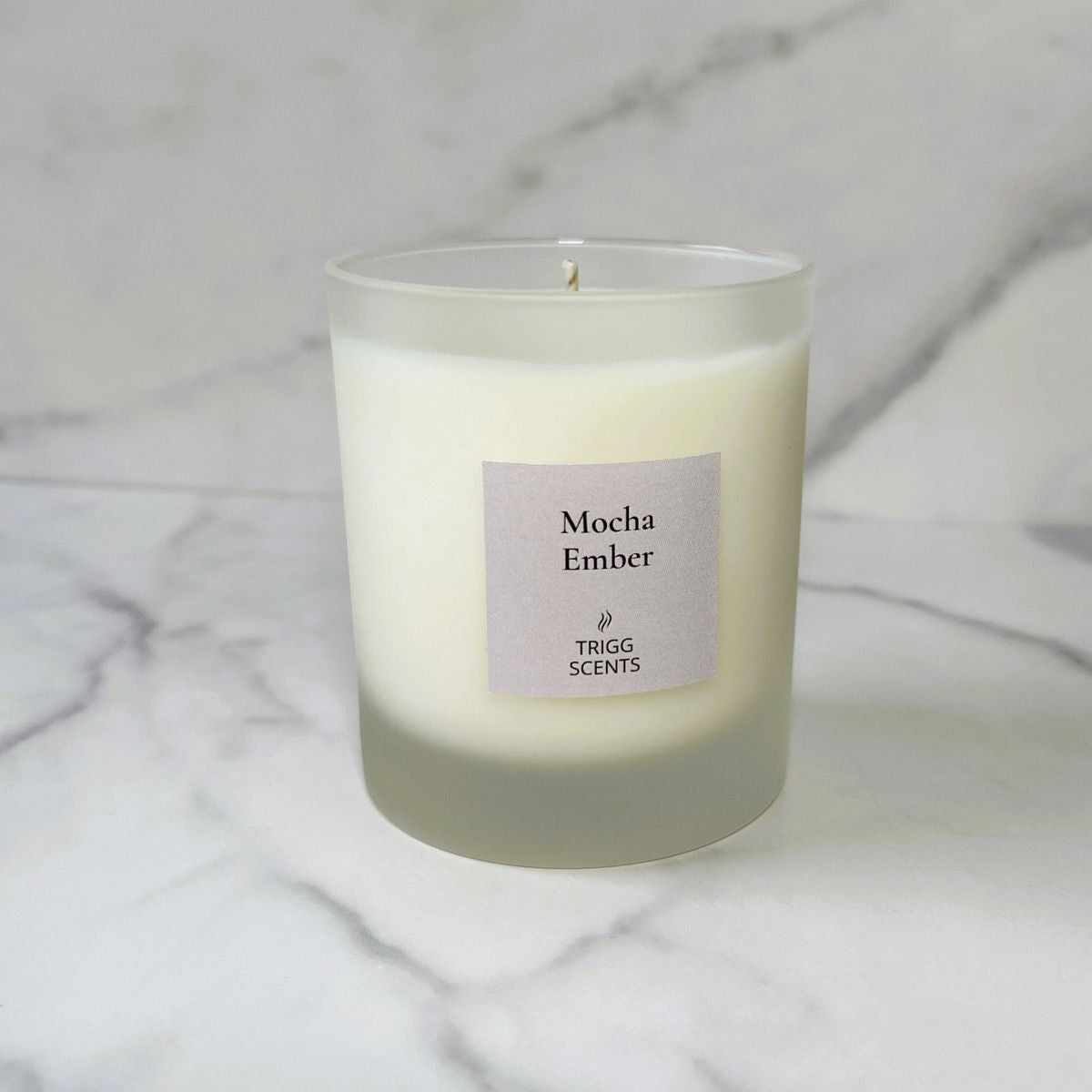 Mocha Ember scented candle with coffee and cocoa fragrance on marble background